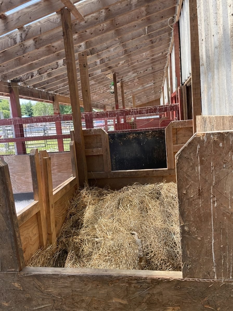 A covered round bale hay feeder full of hay