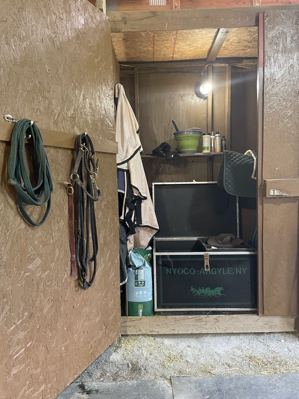 A private storage locker with a tack trunk, halters and blankets